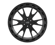 Black car wheel with intricate spoke design.