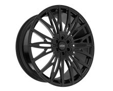 Black, multi-spoke car wheel on black background.